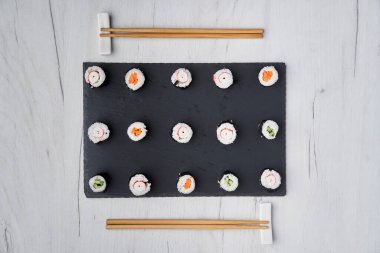 Tahta bir tahtanın üzerinde çeşitli suşi çeşitleri yatıyordu.