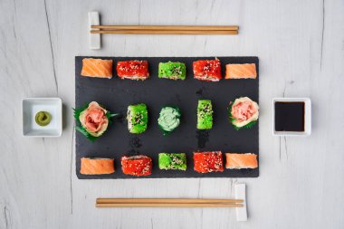 Tahta bir tahtanın üzerinde çeşitli suşi çeşitleri yatıyordu.