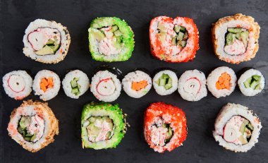 Tahta bir tahtanın üzerinde çeşitli suşi çeşitleri yatıyordu.