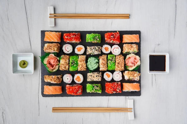 Flat lay shot of a variety of sushi on a wooden board