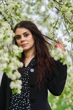 Genç bir kadın parkta bahar yağmurunun tadını çıkarıyor.