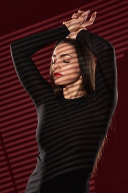 Kırmızı arka planda çekici bir genç kadının portresi.