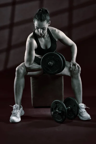 强壮的女人坐着 用哑铃做二头肌卷曲运动 — 图库照片