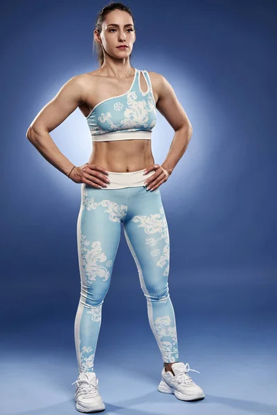 Mujer Atlética Joven Posando Sobre Fondo Azul Traje Gimnasio —  Fotos de Stock