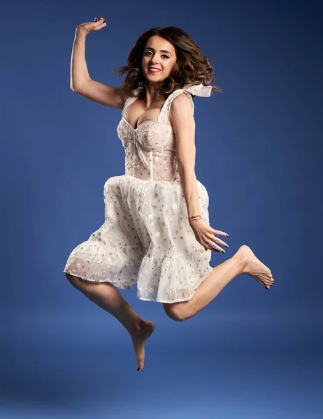 Portrait Beautiful Young Woman White Dress Jumping Joy Blue Background —  Fotos de Stock