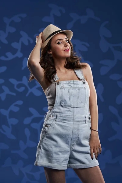 Beautiful Young Woman Denim Overalls Floral Blue Background Studio Shot — Stock fotografie