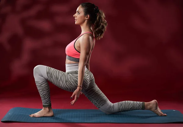 Attractive Young Woman Practicing Yoga Red Background Studio Shot — Zdjęcie stockowe