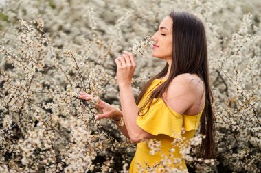 Yazın sonlarında, siyah dikenli çalıların yanındaki sarı elbiseli güzel bir kadının portresi.