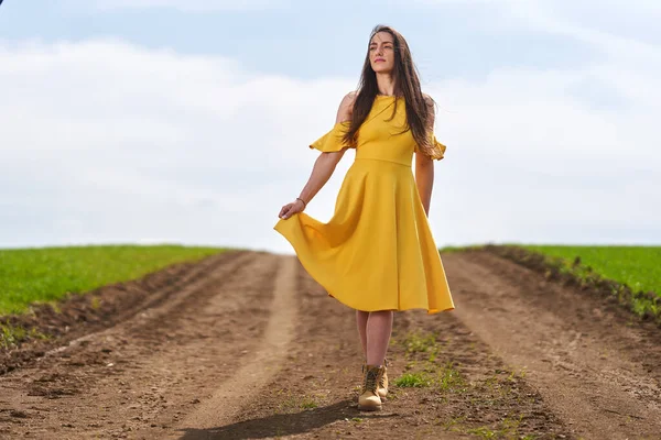 Sarı Elbiseli Genç Kadın Buğday Tarlalarının Arasında Toprak Bir Yolda — Stok fotoğraf