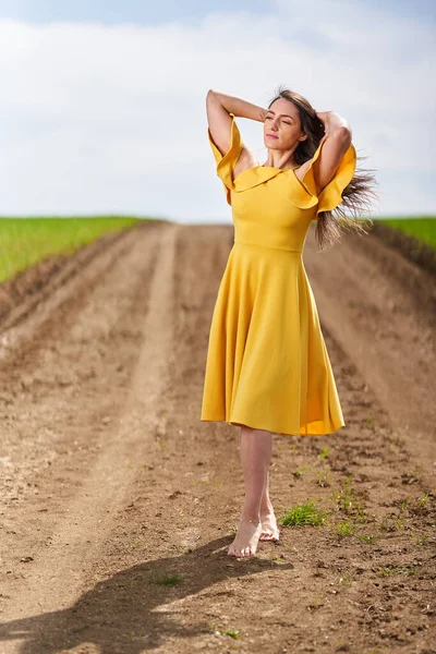 Descalço Jovem Mulher Vestido Amarelo Uma Estrada Terra Entre Campos — Fotografia de Stock