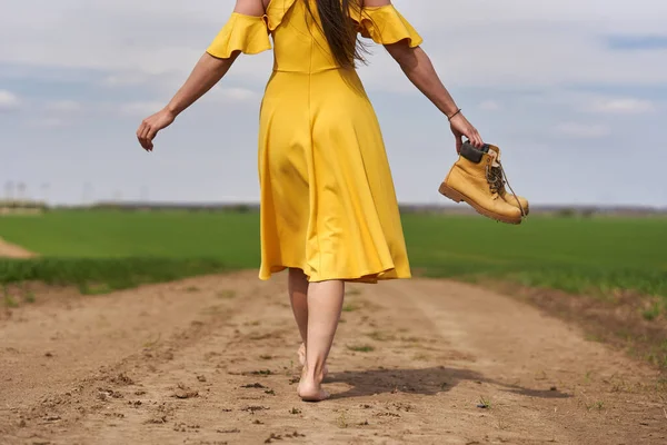 Descalço Jovem Mulher Vestido Amarelo Uma Estrada Terra Entre Campos — Fotografia de Stock