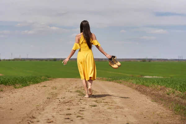 Descalço Jovem Mulher Vestido Amarelo Uma Estrada Terra Entre Campos — Fotografia de Stock