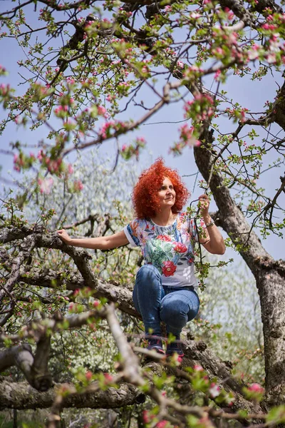 今赤い頭の農家の女性で彼女のリンゴの庭で満開 — ストック写真