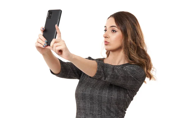 幸せな若い実業家は彼女のスマートフォンで自撮り 白い背景に隔離されました — ストック写真