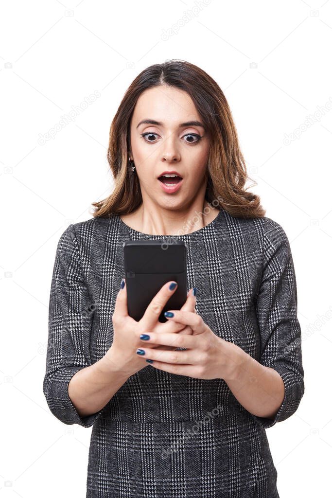 Businesswoman with a very surprised expression, looking at her smartphone, isolated on white background