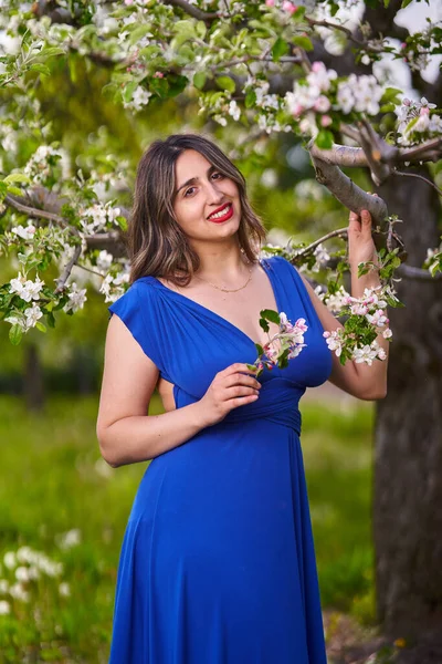 在苹果园里穿着蓝色长裙的年轻漂亮的印度女人 — 图库照片