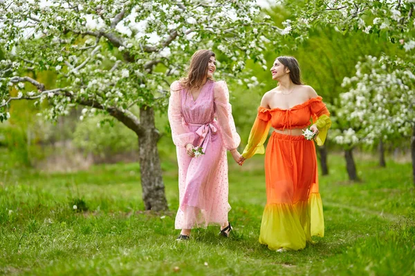 两个印第安人和白人妇女 混血儿 手牵手走在一个盛开的苹果园里 — 图库照片