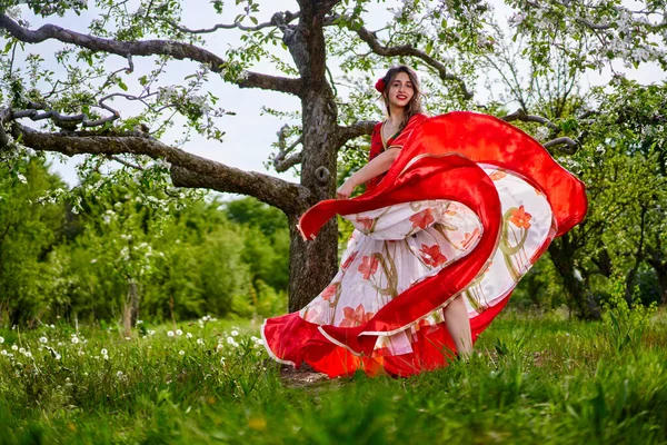 穿着传统吉普赛服装的年轻女子在苹果园里跳舞 — 图库照片