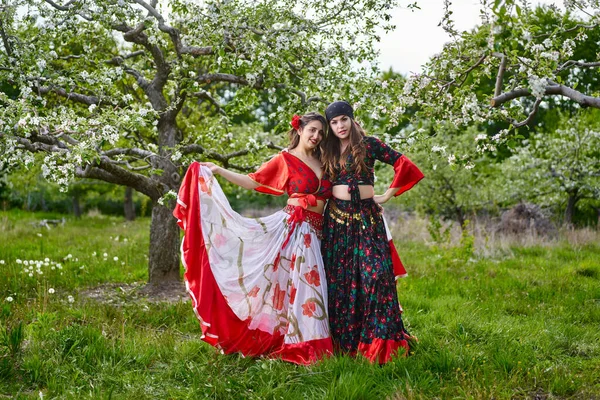 Két Fiatal Hagyományos Cigány Jelmezben Táncol Egy Virágzó Almás Gyümölcsösben — Stock Fotó