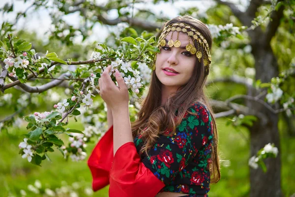 伝統的なジプシーのドレスとスカーフの若い女性のクローズアップ肖像 開花リンゴ園で — ストック写真