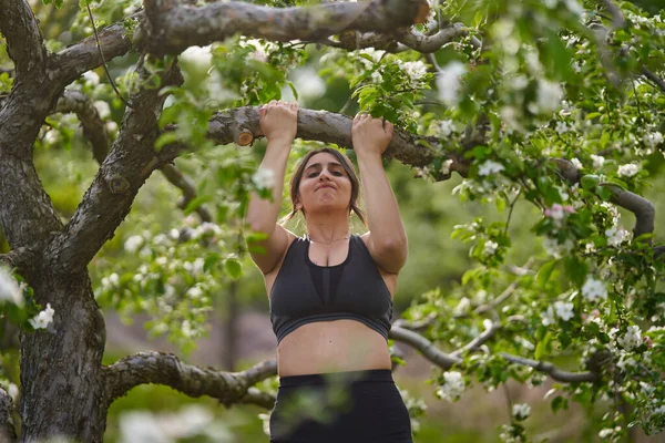 Size Indian Woman Doing Chinups Apple Tree Branch Flowers — Stock Photo, Image