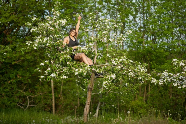 Mooie Maat Sportieve Vrouw Fitness Kleding Klimmen Een Bloeiende Appelboom — Stockfoto