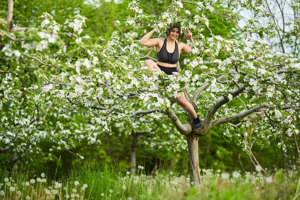 Krásná Velikost Sportovní Žena Fitness Oblečení Lezení Kvetoucí Jabloně Sadu — Stock fotografie