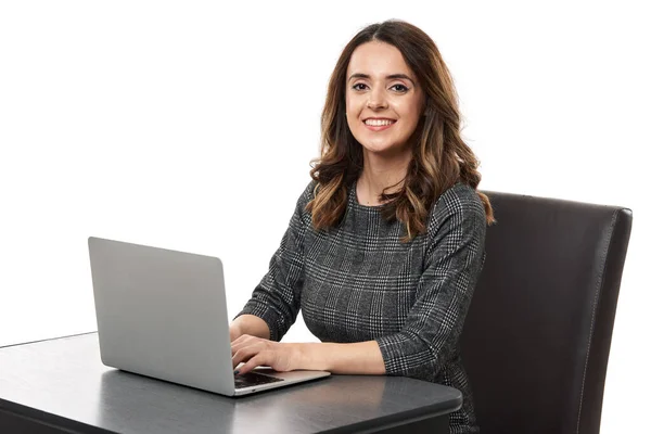 快乐而成功的年轻女商人在她的办公桌前 在她的笔记本电脑上工作 与白色背景隔离 — 图库照片