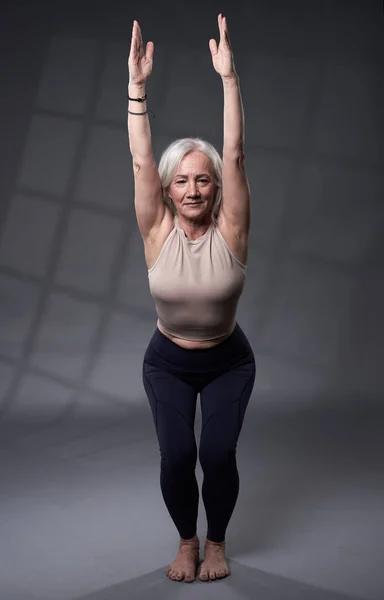 Старша Жінка Білим Волоссям Тренує Йогу Студійний Знімок Сірому Фоні — стокове фото