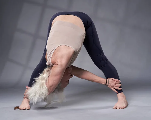 Старша Жінка Білим Волоссям Тренує Йогу Студійний Знімок Сірому Фоні — стокове фото