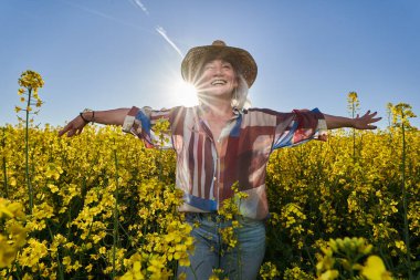 Kanola tarlasında beyaz saçlı güzel bir son sınıf öğrencisi.