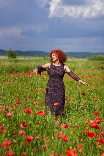 Σγουρά Μαλλιά Κοκκινομάλλα Γυναίκα Floral Φόρεμα Ένα Χωράφι Παπαρούνες — Φωτογραφία Αρχείου