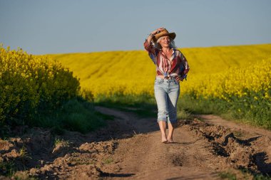 Kanola tarlasında beyaz saçlı güzel bir son sınıf öğrencisi.