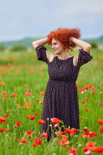 Σγουρά Μαλλιά Κοκκινομάλλα Γυναίκα Floral Φόρεμα Ένα Χωράφι Παπαρούνες — Φωτογραφία Αρχείου