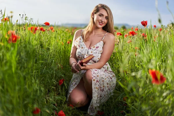 Haşhaş tarlasında çiçek desenli elbiseler giyen güzel, iri yarı Hintli bir kadın.