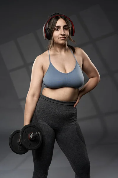 強いサイズプラスインドの女性は グレーの背景に 重量でフィットネスワークアウトを行う — ストック写真