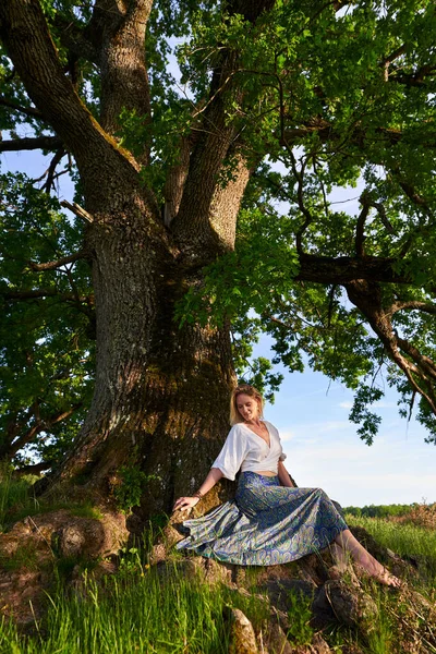 魅力的な若いですブロンド女性Posingによって巨大な百年木で日没 — ストック写真