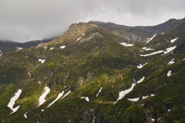 Yaz başında dağ zirveleri ve karla kaplı bir manzara.