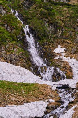 Yazın başlarında dağlarda şelaleli bir manzara.