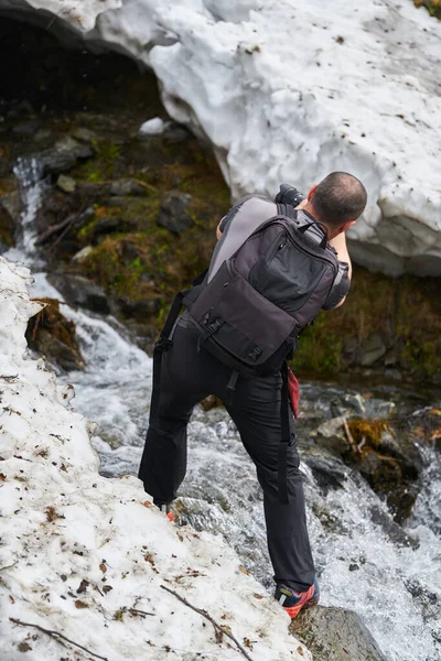 雪の中で滝を撮る自然写真家 — ストック写真