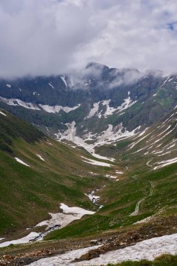 Yaz başında dağ zirveleri ve karla kaplı bir manzara.