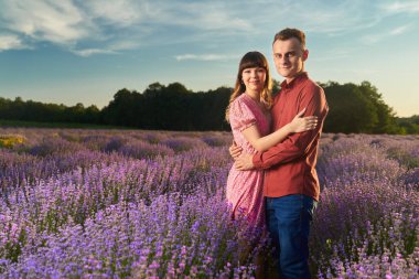 Gün batımında lavanta tarlasında harika vakit geçiren genç bir çift.