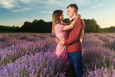 Gün batımında lavanta tarlasında harika vakit geçiren genç bir çift.
