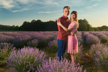 Gün batımında lavanta tarlasında harika vakit geçiren genç bir çift.