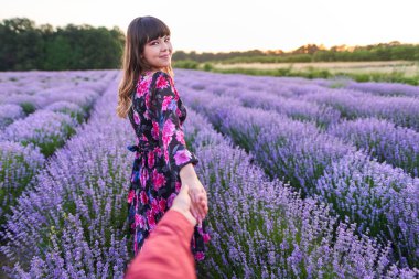 Gün batımında lavanta tarlasında harika vakit geçiren genç bir çift.