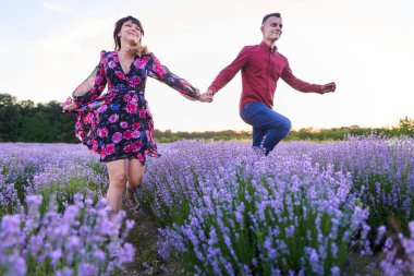 Gün batımında lavanta tarlasında harika vakit geçiren genç bir çift.