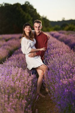 Gün batımında lavanta tarlasında harika vakit geçiren genç bir çift.