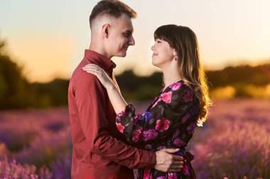 Gün batımında lavanta tarlasında harika vakit geçiren genç bir çift.