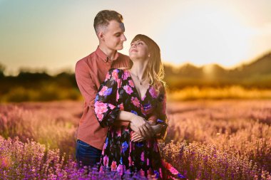 Gün batımında lavanta tarlasında harika vakit geçiren genç bir çift.