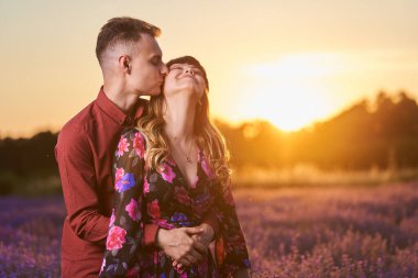 Gün batımında lavanta tarlasında harika vakit geçiren genç bir çift.